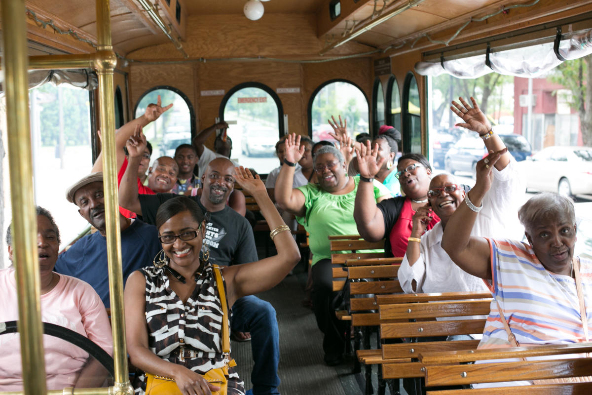 Happy guests waving during the Stroll Down Memory Lane North Omaha Trolley Tour